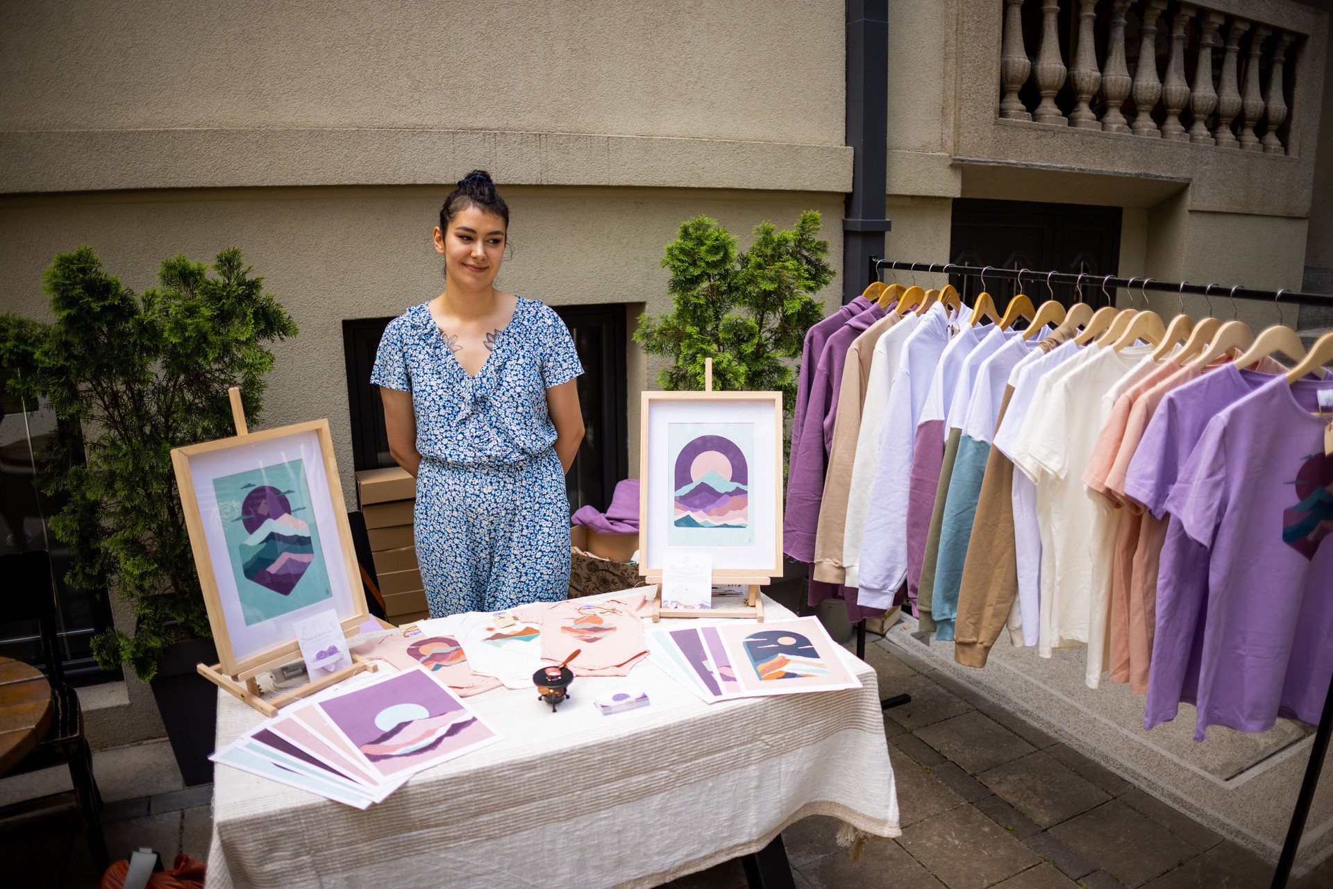 Portrait of a young Caucasian female artist, with her art products, during the art fair